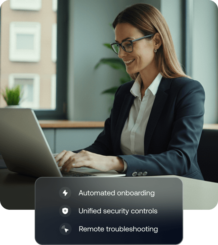 A professional woman working on a Mac laptop in an office setting, representing macOS device management and productivity.