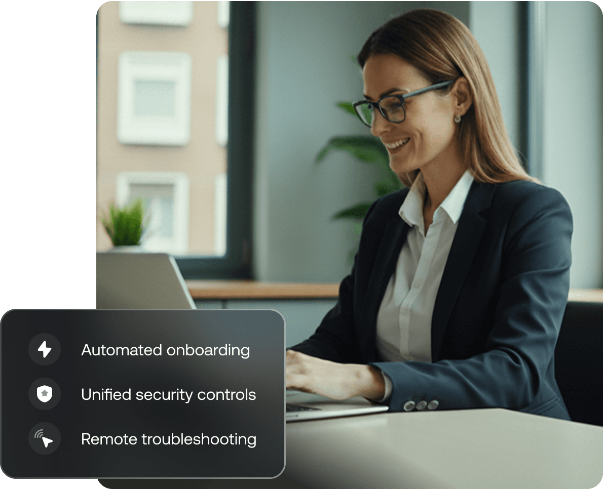 A professional woman working on a Mac laptop in an office setting, representing macOS device management and productivity.