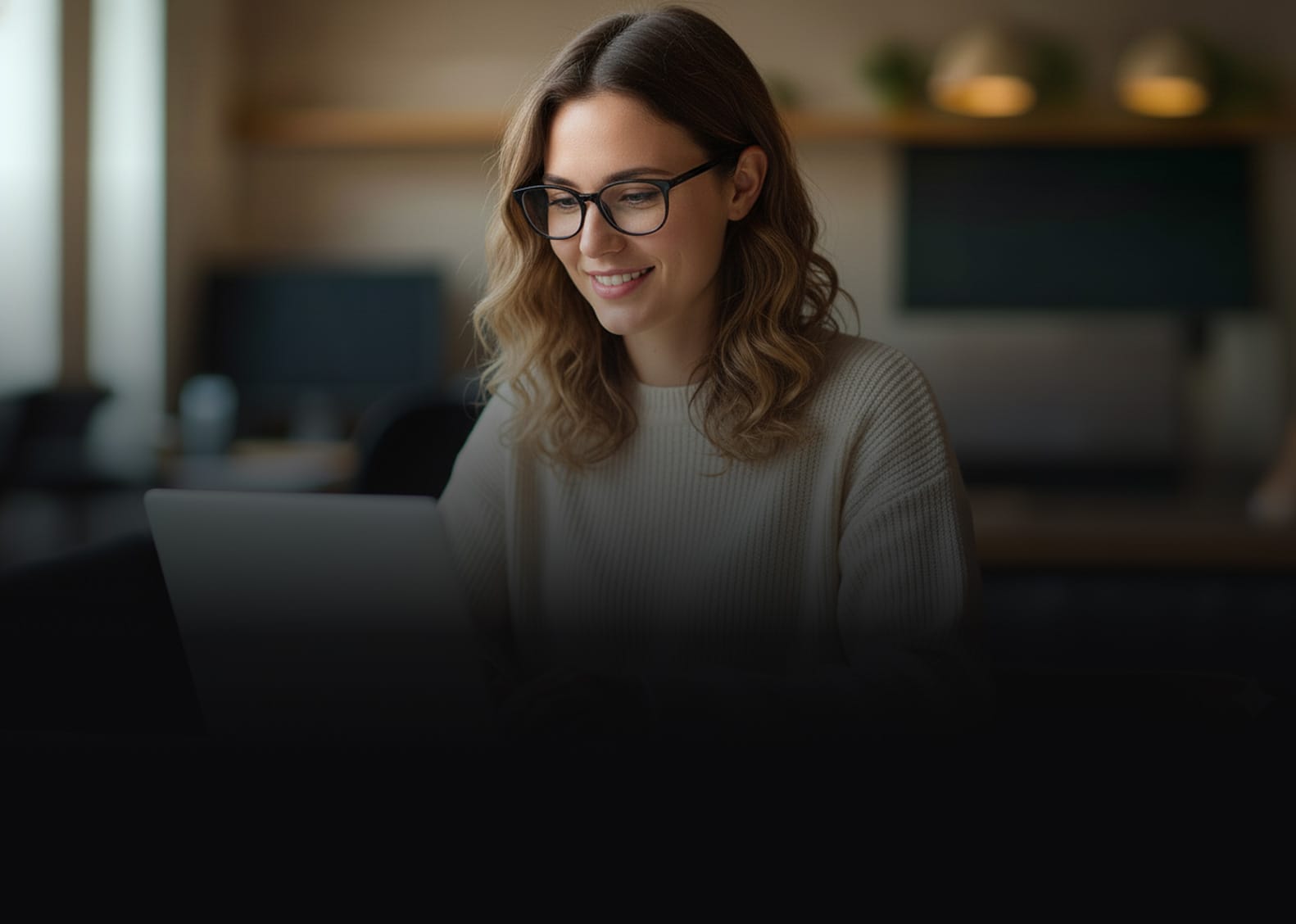 A happy user leveraging Hexnode, smiling while working efficiently on a laptop.