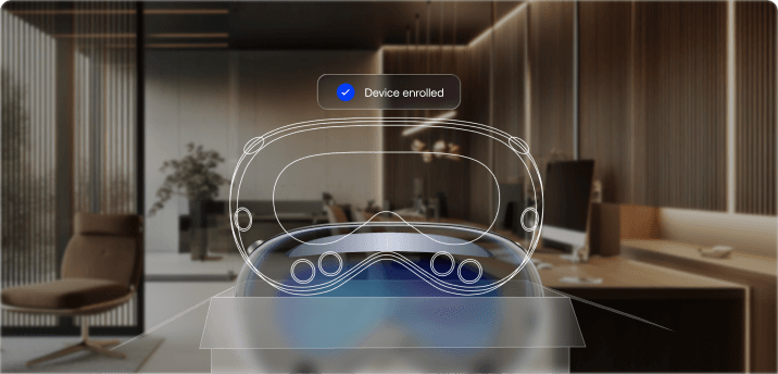 A Vision Pro with a wireframe overlay, showing a floating notification that reads 'Device enrolled' in a blurred office background.